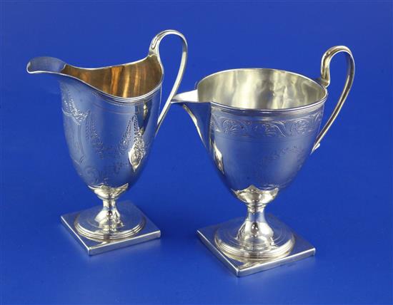 A George III silver vase form cream jug and a similar helmet shaped cream jug 8 oz.